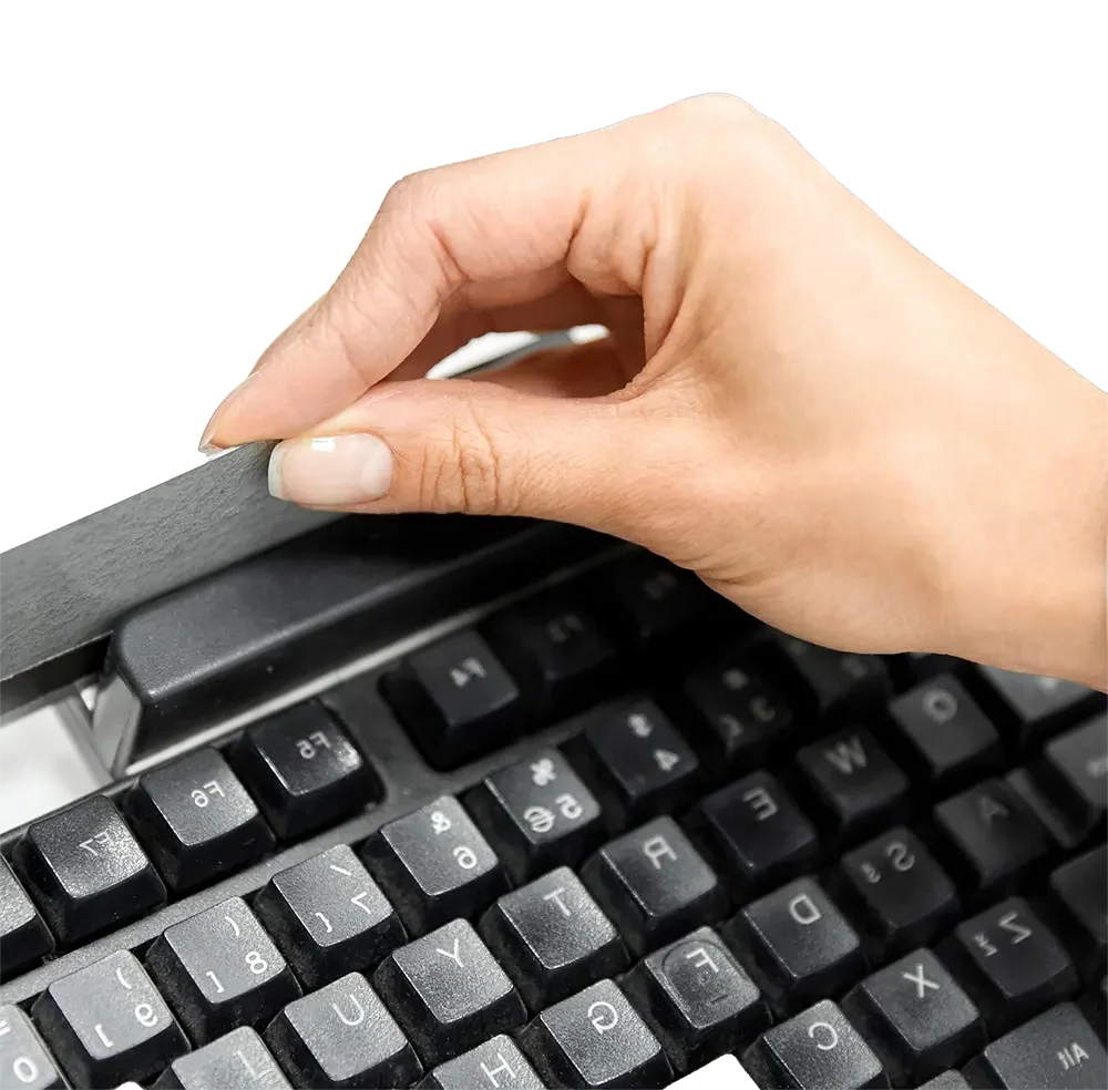 a female's hands running a credit card through a credit card reader on a black keyboard, depicting credit card processing